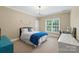 Cozy bedroom featuring a bed with a blue throw blanket and a window with natural light at 6132 Sharon Rd, Charlotte, NC 28210