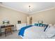 A comfortable bedroom with a bright blue throw blanket, a work desk, and natural light at 6132 Sharon Rd, Charlotte, NC 28210
