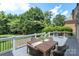 Outdoor deck with dining table, wicker chairs, and scenic backyard views at 6132 Sharon Rd, Charlotte, NC 28210