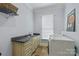 Functional laundry room with sink, cabinet storage, and modern washer and dryer at 6132 Sharon Rd, Charlotte, NC 28210