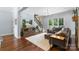 Spacious living room with a staircase, hardwood floors, and a comfortable sofa at 6132 Sharon Rd, Charlotte, NC 28210