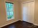 A simple bedroom with a window and closet, featuring modern flooring at 7212 Bradley Ct, Charlotte, NC 28227