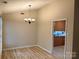 Spacious dining room with modern light fixture, wood floors, and view into the kitchen at 7212 Bradley Ct, Charlotte, NC 28227