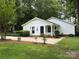 Charming home featuring a well-maintained lawn, a partial brick facade, and eye-catching blue shutters at 7212 Bradley Ct, Charlotte, NC 28227
