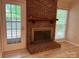 Cozy living room with brick fireplace, mantle, and door to outside at 7212 Bradley Ct, Charlotte, NC 28227