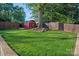 Lush backyard with a red shed, mature tree, and wood fence at 8007 Maxwelton Dr, Huntersville, NC 28078