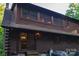 Exterior view of a log home showcasing multiple windows, a door, and natural landscaping at 95 Odell Ct, Taylorsville, NC 28681