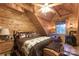 This wood-clad bedroom features a rustic-style décor, ceiling fan and wood-burning stove for warmth at 95 Odell Ct, Taylorsville, NC 28681