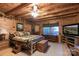 Cozy bedroom featuring wood paneling, wood flooring, ceiling fan and a large picture window at 95 Odell Ct, Taylorsville, NC 28681
