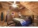 This bedroom features wood paneling, a queen bed, rustic decor, and an ensuite bathroom at 95 Odell Ct, Taylorsville, NC 28681