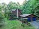 A charming two-story home with wood siding, a front porch, and a detached garage at 95 Odell Ct, Taylorsville, NC 28681