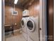 Basement laundry room with updated washer, dryer, and wood paneling at 95 Odell Ct, Taylorsville, NC 28681