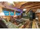 Rustic living room featuring wood paneling, multiple windows, comfortable seating, and an entertainment center at 95 Odell Ct, Taylorsville, NC 28681