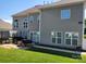 Large backyard with green lawn, patio area, grill, and well-maintained exterior of the home at 103 Doyle Farm Ln, Mooresville, NC 28115