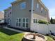 Spacious backyard featuring a fire pit, privacy fence, green lawn, and view of the home's exterior at 103 Doyle Farm Ln, Mooresville, NC 28115