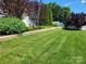 Lush green backyard features a retaining wall with manicured landscaping and a privacy fence at 103 Doyle Farm Ln, Mooresville, NC 28115