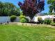 Well-manicured backyard features a retaining wall, lush greenery, mature trees, and a privacy fence at 103 Doyle Farm Ln, Mooresville, NC 28115