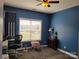 Bedroom with gray carpet, blue walls, ceiling fan, and view to front yard at 103 Doyle Farm Ln, Mooresville, NC 28115
