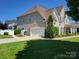 Exterior showcasing the attached garage and manicured lawn of this well-maintained home at 103 Doyle Farm Ln, Mooresville, NC 28115