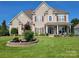 Beautiful two-story home with a manicured lawn, a welcoming front porch, and colorful flower beds at 103 Doyle Farm Ln, Mooresville, NC 28115