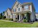 Charming two-story home with a welcoming front porch, manicured lawn, and beautiful landscaping at 103 Doyle Farm Ln, Mooresville, NC 28115