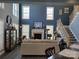 Bright and inviting living room with tall windows, fireplace, and comfortable seating; perfect for relaxation at 103 Doyle Farm Ln, Mooresville, NC 28115