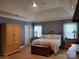 Main bedroom with tray ceiling, wood floors, and armoire at 103 Doyle Farm Ln, Mooresville, NC 28115