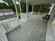 Spacious back porch with railings, a chair, and views of the backyard and garages at 103 Duke St, Great Falls, SC 29055