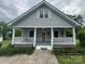 Charming gray home featuring a cozy front porch with white railings and a well-manicured lawn at 103 Duke St, Great Falls, SC 29055
