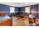 Bedroom with hardwood floors, two windows, and baseboard trim on walls with blue paint at 106 Deaver St, Chester, SC 29706