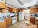 Kitchen features oak cabinets, a white refrigerator and laundry in the back at 106 Deaver St, Chester, SC 29706