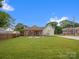 Large, well-maintained backyard featuring a covered patio, fire pit, and wooden privacy fence at 107 Pressley St, Clover, SC 29710