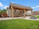 Inviting covered backyard patio with outdoor dining area, fire pit, and swing for relaxing and entertaining at 107 Pressley St, Clover, SC 29710