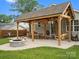 Inviting covered backyard patio with outdoor dining area, fire pit, and swing for relaxing and entertaining at 107 Pressley St, Clover, SC 29710
