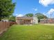 Large, well-maintained backyard featuring a covered patio, fire pit, and wooden privacy fence at 107 Pressley St, Clover, SC 29710