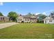 Green, grassy lawn surrounds single story home with wood beams and shutters at 107 Pressley St, Clover, SC 29710