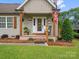 Inviting front porch with wooden posts, a rocking chair, and an American flag at 107 Pressley St, Clover, SC 29710