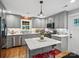 Modern kitchen features gray cabinets, marble countertops and a functional island with seating at 107 Pressley St, Clover, SC 29710