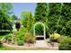 Serene backyard featuring a charming garden bench with colorful pillows surrounded by lush foliage at 1110 Archer Farm Dr, Salisbury, NC 28144
