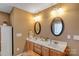 A bathroom featuring double sinks, oval mirrors and wood cabinetry, creating a functional space at 1110 Archer Farm Dr, Salisbury, NC 28144