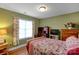 A cozy bedroom with a bed, floral bedding, a desk, a dresser, and a bright window at 1110 Archer Farm Dr, Salisbury, NC 28144