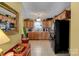 Functional kitchen featuring natural wood cabinets, tile backsplash, and black appliances at 1110 Archer Farm Dr, Salisbury, NC 28144