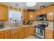 Close-up of kitchen with wooden cabinets, neutral countertops, tile backsplash and stainless steel appliances at 1110 Archer Farm Dr, Salisbury, NC 28144