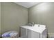 A compact laundry room features a side-by-side washer and dryer, plus space for a laundry basket at 1110 Archer Farm Dr, Salisbury, NC 28144