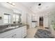 Main bathroom featuring double sinks, granite counters, a shower, and a walk-in closet at 1111 Thessallian Ln, Indian Trail, NC 28079