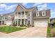 Two-story home featuring a charming front porch, well-manicured lawn, and lush landscaping at 1111 Thessallian Ln, Indian Trail, NC 28079
