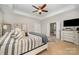 Bright main bedroom with a tray ceiling, ceiling fan, and en suite bathroom access at 1111 Thessallian Ln, Indian Trail, NC 28079