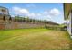 Expansive backyard featuring lush green lawn, retaining wall with fence and landscaping, perfect for outdoor activities at 1318 Encore Ln, Waxhaw, NC 28173