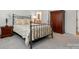 Bedroom featuring a metal bed frame, floral bedding, and a wooden wardrobe at 1318 Encore Ln, Waxhaw, NC 28173