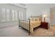 Bedroom with a metal bed frame, floral bedding, and plantation shutters at 1318 Encore Ln, Waxhaw, NC 28173